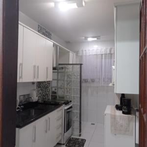 カンポス・ドス・ゴイタカゼスにあるCampos Rede Apto Xのシンクとコンロのある白いキッチン