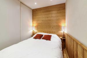 ein Schlafzimmer mit einem weißen Bett mit zwei braunen Kissen in der Unterkunft Cosy flat with terrace in Huez - Welkeys in Huez