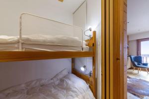 a bedroom with two bunk beds and a desk at Cosy flat with terrace in Huez - Welkeys in LʼHuez