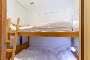 a bunk bed in a room with a ladder and a bunk bed sidx sidx sidx at Cosy flat with terrace in Huez - Welkeys in LʼHuez