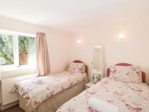 a bedroom with two beds and a window at Ryecross Farm Cottage in Melbury Abbas