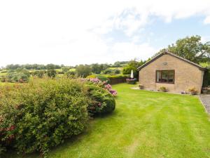 a stone house with a yard with flowers at Ryecross Farm Cottage in Melbury Abbas