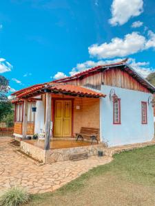 uma pequena casa com um banco à frente em Serra a vista Chalé em Prados