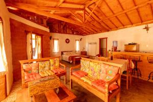 a living room with couches and a bed in a room at Serra a vista Chalé in Tiradentes