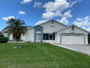 a white house with a palm tree in the yard at All Homes With Private Pool in Kissimmee