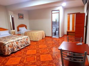 una camera d'albergo con due letti e un tavolo di Antares Inn a Lima