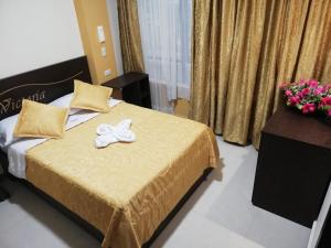 una camera da letto con un letto con un fiocco bianco di Victoria Suites Hotel a Santo Domingo de los Colorados