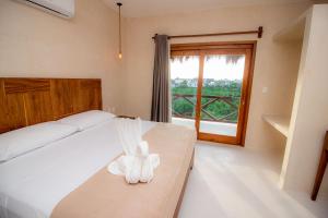 Una habitación de hotel con una cama con una toalla. en Hotel Luna Roja Holbox, en Isla Holbox