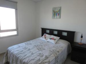 a bedroom with a bed with two pillows on it at Departamento con vista al mar in Puerto Madryn +29 photos