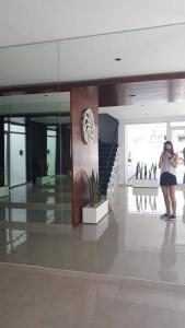 a woman taking a picture of a building at Departamento con vista al mar in Puerto Madryn