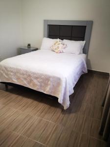 a bedroom with a large white bed with a wooden floor at 2-bedroom apartment centrally located, near us consulate in Ciudad Juárez