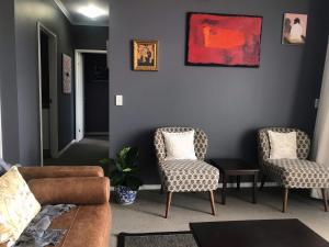 a living room with a couch and two chairs at The Perfect Host @ Curtis Apartments in Gladstone