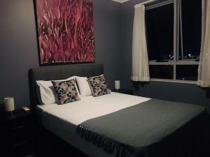1 dormitorio con 1 cama con una pintura en la pared en The Perfect Host @ Curtis Apartments, en Gladstone
