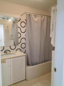 a bathroom with a shower curtain and a sink at SolTroia - Casa do Pinheiro in Troia