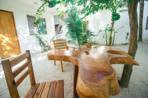drewniany stół w pokoju z krzesłami i drzewami w obiekcie Posada Yalekin Holbox w mieście Isla Holbox