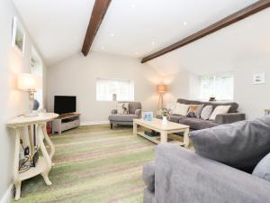 a living room with two couches and a tv at Peewit Barn in Moreton in Marsh