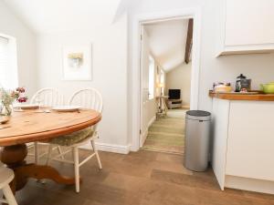 a kitchen and dining room with a wooden table at Peewit Barn in Moreton in Marsh