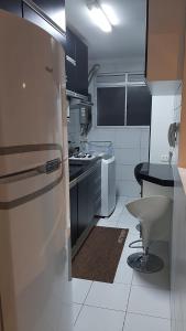 a kitchen with a refrigerator and a table in it at Apto Cruzeiro do Sul com Wi-Fi in São José dos Pinhais