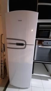 a white refrigerator in a kitchen next to a stove at Apto Cruzeiro do Sul com Wi-Fi in São José dos Pinhais