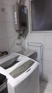 a kitchen with a sink and a microwave at Apto Cruzeiro do Sul com Wi-Fi in São José dos Pinhais