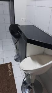 a bathroom with a black counter and a white toilet at Apto Cruzeiro do Sul com Wi-Fi in São José dos Pinhais