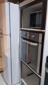 a kitchen with a refrigerator and a microwave at Apto Cruzeiro do Sul com Wi-Fi in São José dos Pinhais