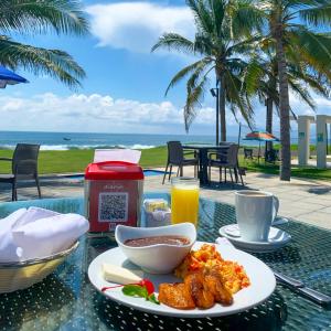 una mesa con un plato de comida en una mesa con la playa en Hotel El Faro, en Monterrico