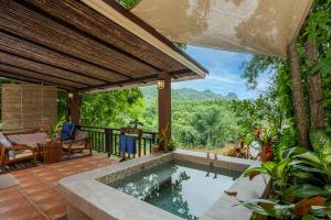 an outdoor pool with a view of the mountains at Home Phutoey River Kwai Hotspring & Nature Resort in Sai Yok