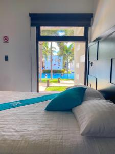 Una cama con una almohada azul encima en Hotel El Faro, en Monterrico