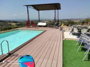 Calvi dellʼ UmbriaにあるGiardino casa Selciataの木製デッキ(テーブル、椅子付)のスイミングプール