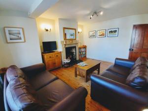 a living room with a couch and a fireplace at Beaconsfield Cottage in Briston