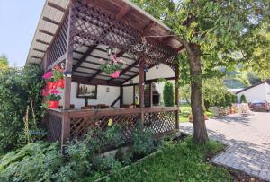 a wooden gazebo with flowers in a yard at Casa Girbacea in Şimon