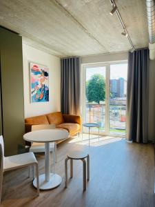 a living room with a couch and tables and a window at Campus House by Larsen in Tallinn