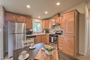 a kitchen with wooden cabinets and a wooden table at Bright and Modern Flagstaff Cottage Escape! in Mountainaire