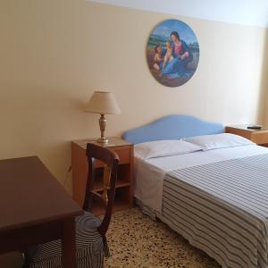 パレルモにあるプロフューモ ディ シチリアのベッドルーム1室(ベッド1台、テーブル、壁の絵付)