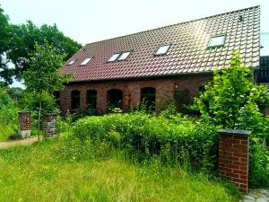 an old brick house with a red roof at Der Eulenblick - Seminarhaus, Ferienhaus, Gästehaus, Reitstation, Am Waldrand in Tewswoos