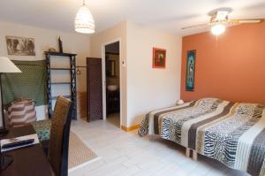 a bedroom with a bed and a desk and a table at Le relais de Roscarven in Gouesnou