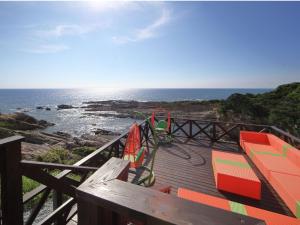 um deque com um parque infantil com vista para o oceano em XYZ speciale em Shirahama