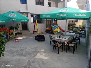 patio ze stołem, krzesłami i parasolami w obiekcie Къща за гости Калинови w mieście Sandanski