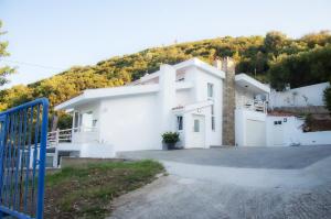 una casa blanca con una colina en el fondo en Maria Olive and Sea Villa, en Nea Iraklitsa