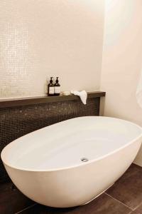 a white bath tub sitting in a bathroom at Beach Club in Hamilton Island