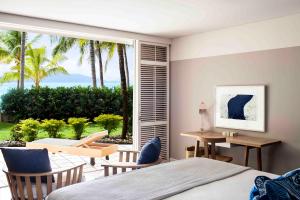 a bedroom with a bed and a view of the ocean at Beach Club in Hamilton Island
