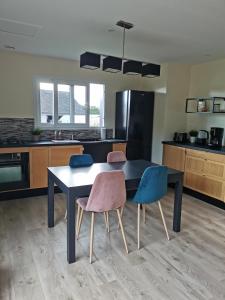 a kitchen with a black table and two chairs at Maison-Gîte "au bord de l'oust "avec jacuzzi in La Chapelle