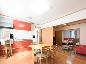 a kitchen and living room with a table and chairs at Tama Hotel in Ishinomaki