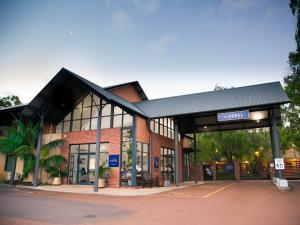 een gebouw met een bord aan de voorkant bij Presidential Bungalow in Busselton