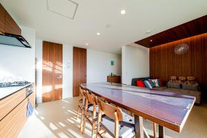 a kitchen with a large wooden table and chairs at Onna Beach Square -恩納ビーチスクエア- in Onna +49 photos