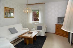 a living room with a white couch and a table at 3 Sterne Ferienwohnungen Wachter in Bischofsgrün