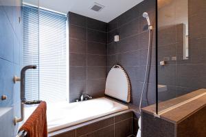 a bathroom with a bath tub and a shower at Onna Beach Square -恩納ビーチスクエア- in Onna