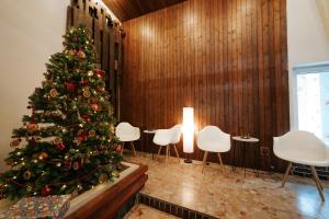 a christmas tree in a room with white chairs at Dom horskej služby in Terchová