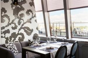 un ristorante con due tavoli, sedie e finestre di Victoria Hotel Vyborg a Vyborg